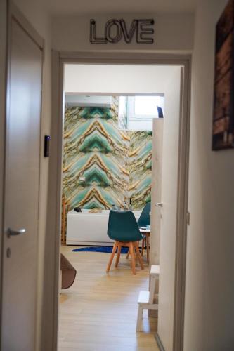 a room with a wall that says love and a green chair at etna sea live catania center home in Catania