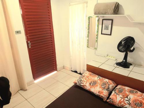 a room with a bed and a mirror and a door at Hospedagem Jabuti no Centro de São Jorge in Sao Jorge
