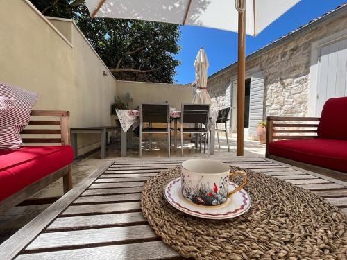 eine Kaffeetasse auf einem Tisch auf einer Terrasse in der Unterkunft Fortuna House Vis in Vis