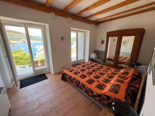 ein Schlafzimmer mit einem Bett und zwei großen Fenstern in der Unterkunft Fortuna House Vis in Vis