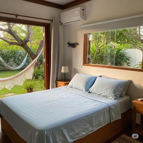 a bedroom with a bed and a large window at Casa Cajuzal Carrapateira in Acaraú