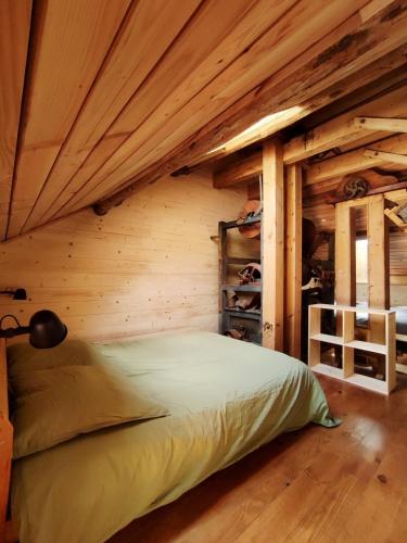 a bedroom with a bed in a log cabin at Le Moulin de la Hire in Miremont