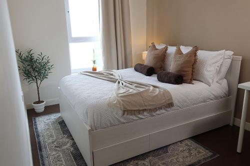 a bedroom with a white bed with pillows and a window at Newcastle City Centre Apartment with Free Private Parking, Walk Away to Quayside in Newcastle upon Tyne