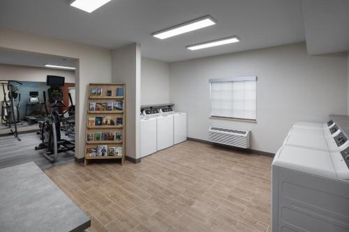 a large room with a gym with a treadmill at Candlewood Suites St. Robert by IHG in Saint Robert