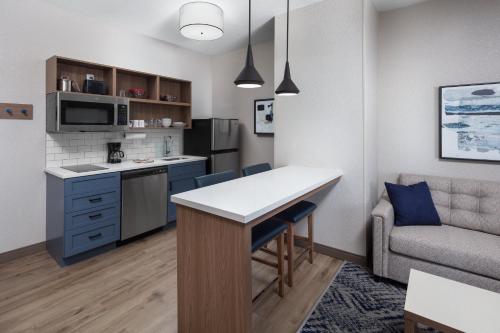 a kitchen and living room with a table and a couch at Candlewood Suites St. Robert by IHG in Saint Robert