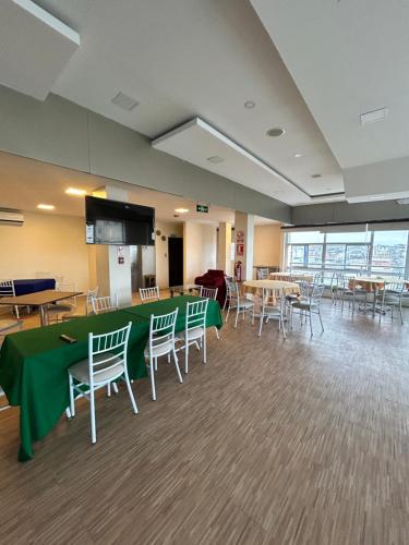 a conference room with tables and chairs and a screen at Hotel Oceanik in Manta