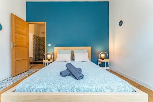a bedroom with a large bed with a blue wall at Le beau Malcousinat place Nationale wifi haut débit in Montauban