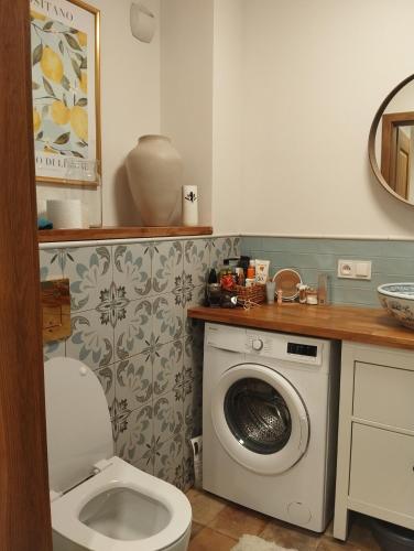 a bathroom with a toilet and a washing machine at Apartament -Podczele in Kołobrzeg