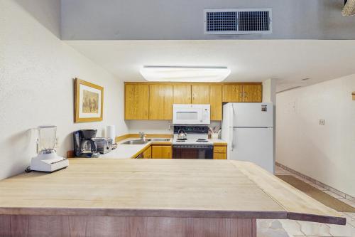 a kitchen with wooden cabinets and a white refrigerator at Summit House East in Copper Mountain