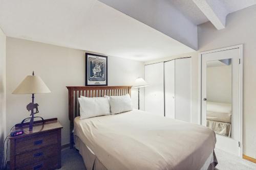 a bedroom with a large white bed and a mirror at Summit House East in Copper Mountain