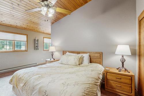 Un dormitorio con una cama y un ventilador de techo. en Hidden Village 700, en Big Sky
