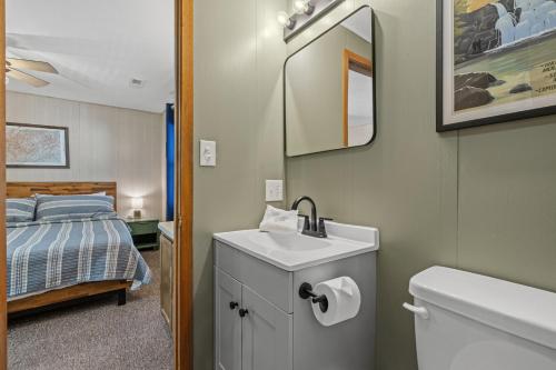 a bathroom with a sink and a toilet and a bed at A Tram View Scenic Mountain Views and see the Gatlinburg historic cable tram pass by in Gatlinburg