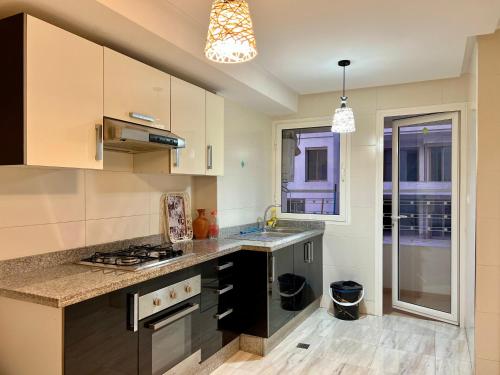 a kitchen with a sink and a stove top oven at Prestigia luxury appartement in Fès