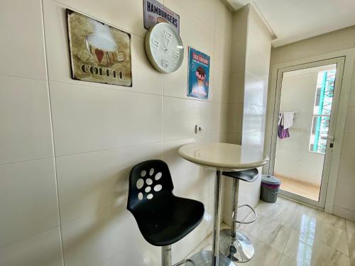 a room with a table and a chair and a clock at Prestigia luxury appartement in Fès