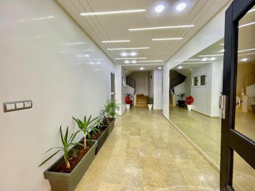 an office hallway with plants on the walls at Prestigia luxury appartement in Fès