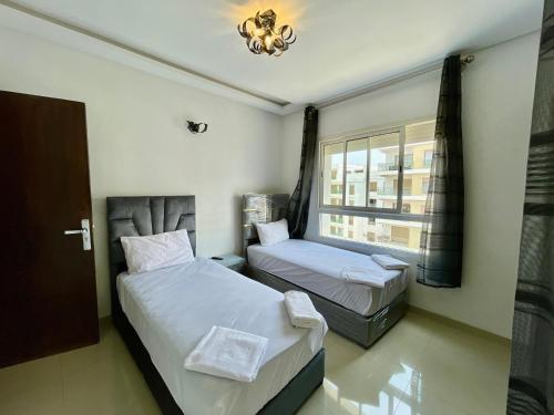 a bedroom with two beds and a window at Prestigia luxury appartement in Fès