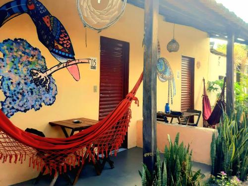 a room with a hammock and a table and chairs at Hospedagem Jabuti no Centro de São Jorge in Sao Jorge
