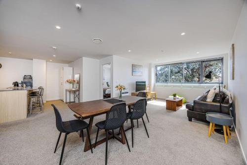 a dining room and living room with a table and chairs at Eden Vista 3 bedroom Apartment with free parking in Auckland