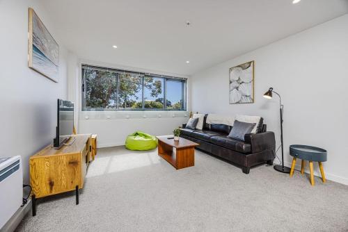 a living room with a couch and a table at Eden Vista 3 bedroom Apartment with free parking in Auckland