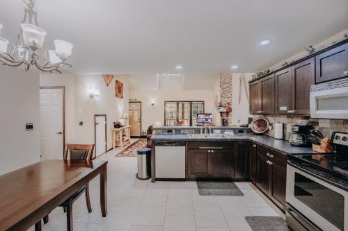 a large kitchen with wooden cabinets and a table at Glacier Springs Cabin 89 Cedar and Log Cabin close to skiing and hiking in Deming
