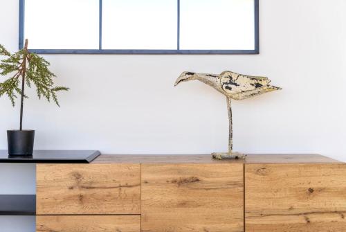 a wooden dresser with a bird sculpture on top of it at Mara's Apartments Higuerón West -Blue Horizon - Seaviews in Fuengirola