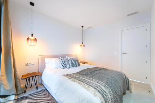 a bedroom with a bed and two pendant lights at Mara's Apartments Higuerón West -Blue Horizon - Seaviews in Fuengirola