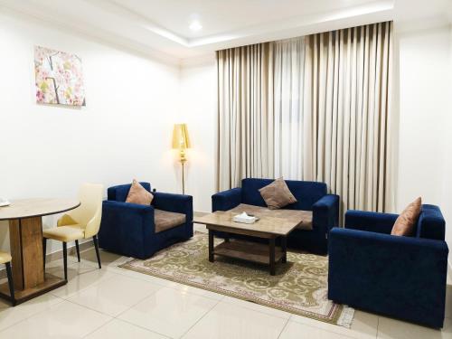 a living room with blue chairs and a table at سكون سويت للشقق الفندقية in Hail