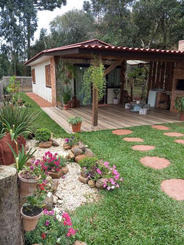 a garden with flowers and plants in front of a house at Cantinho do Sossego in Prudentópolis