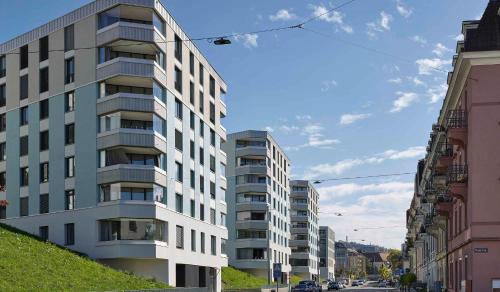 a tall white apartment building on a city street at Zürich 3 Zimmer Wohnung mit Dachterrasse in Zürich
