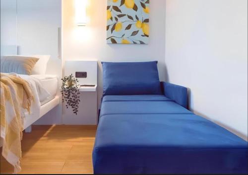 a blue couch in a room next to a bed at ORBI CITY LUXURY deluxe KIG DVD in Batumi