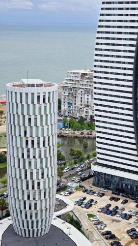 a view of two tall buildings and a parking lot at ORBI CITY LUXURY deluxe KIG DVD in Batumi