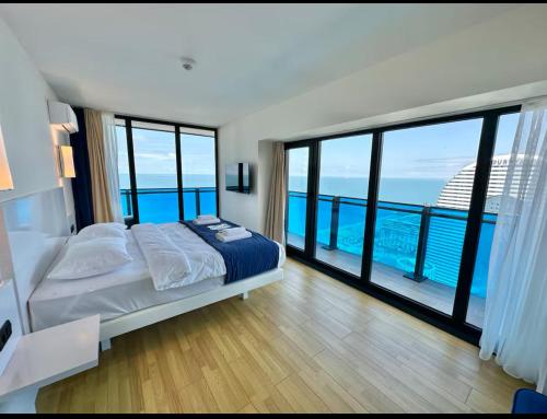 a bedroom with a bed with a view of the ocean at ORBI CITY LUXURY deluxe KIG DVD in Batumi