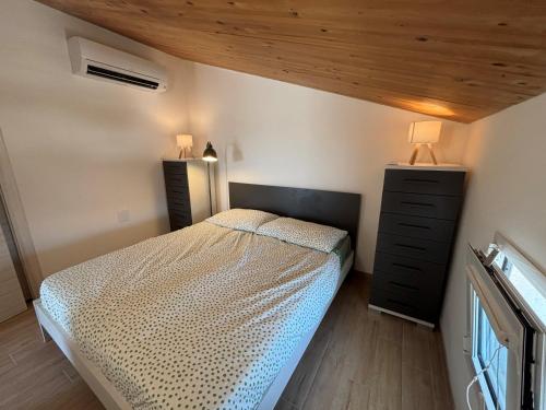 a bedroom with a bed and two dressers in it at Flamingo Apartment in Pachino