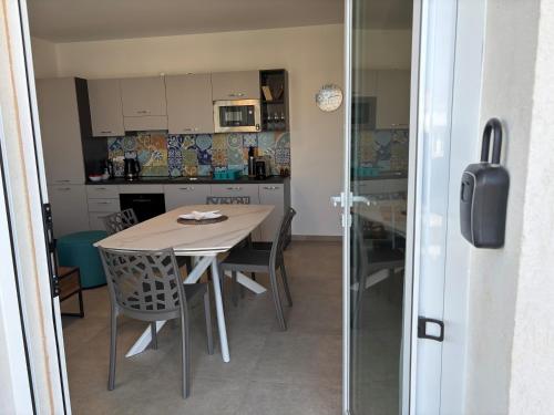 a kitchen and dining room with a table and chairs at Flamingo Apartment in Pachino