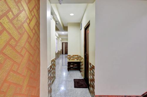 a hallway with white walls and a wooden door at Hotel O Parasol Inn Gangtok in Gangtok
