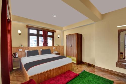 a bedroom with a large bed and a red rug at Hotel O Parasol Inn Gangtok in Gangtok
