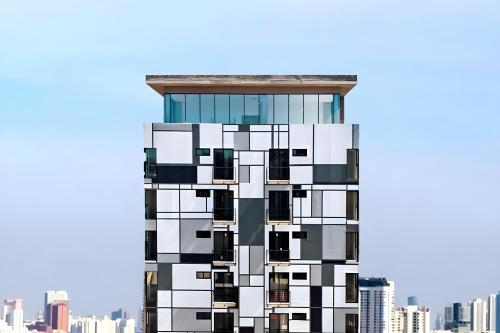 a tall building with black and white windows at Van Alen Haus in Tijuana