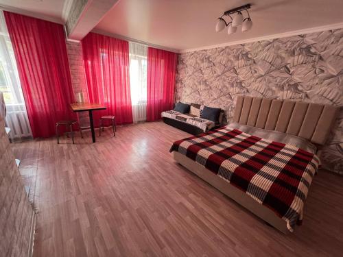 a bedroom with a bed and a couch and a table at Вип Квартира посуточно in Shakhtīnsk