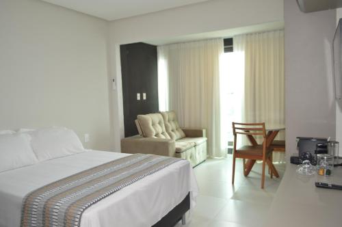 a bedroom with a bed and a chair and a couch at ArtStudio Open Spaces in Salvador