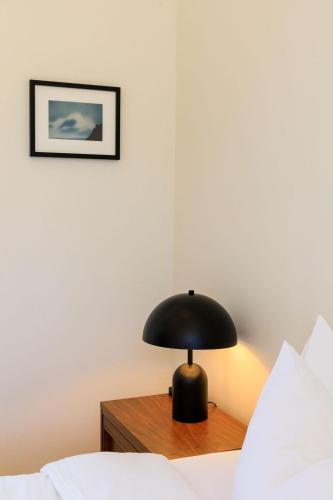 a black lamp sitting on a table next to a bed at The Historic Schoolhouse Inn in Trinidad