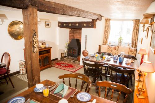 a living room with a table and chairs and a fireplace at Farmhouse Cottage in Sidmouth