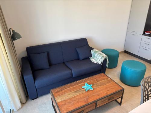 a living room with a blue couch and a coffee table at Flamingo Apartment in Pachino