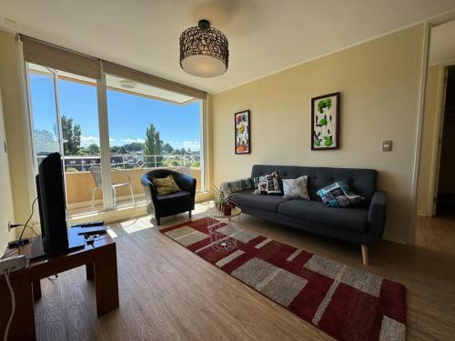 a living room with a couch and a television at Vive la magia de Puerto Varas, tu refugio perfecto the magic of Puerto Varas, your perfect retreat in Puerto Varas