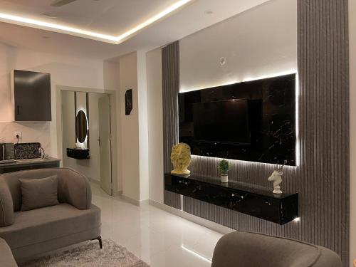 a living room with a couch and a flat screen tv at The Greystone Luxe in Rawalpindi