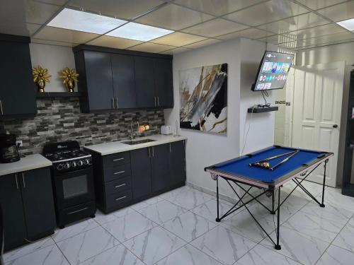 a kitchen with black cabinets and a table in it at Linkzup Europa Condos in Sosúa