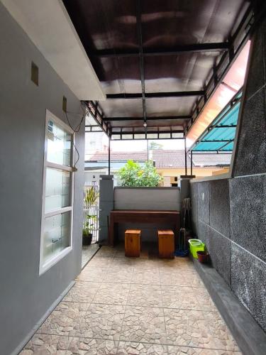 a patio with a bench and a window at LA LUNA Guest House in Banyuwangi