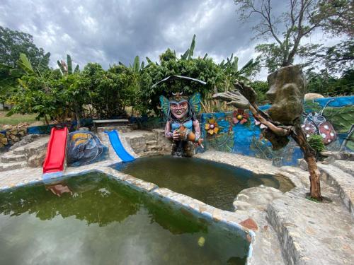 a statue is standing in a pool of water at Finca Turística Las Margaritas in Rivera