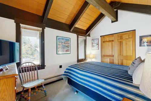 a bedroom with a bed and a desk and a tv at Yellowstone 28B in Big Sky