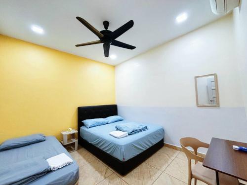 a bedroom with two beds and a ceiling fan at MiuMiu Homestay in Teluk Intan
