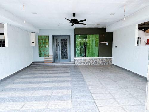 an empty room with a ceiling fan and a door at MiuMiu Homestay in Teluk Intan